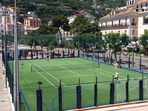 dos personas jugando al tenis en una pista de tenis en De Riso Apartments Luxury Amalfi Coast, en Minori