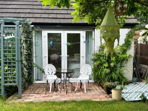 a patio with two chairs and a table in front of a house at Garden Snug in Belfast