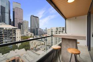 balcón con 2 taburetes y vistas a la ciudad en Bright 2B apt next to Flagstaff Garden freeparking#FG1003, en Melbourne