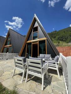 a group of white chairs and a house at Villat Grand in Peje