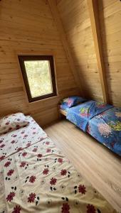 a bedroom with two beds in a wooden cabin at Villat Grand in Peje