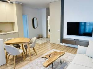 a living room with a table and a tv at Joy City Stay Vivalia 7B-26 in Timişoara