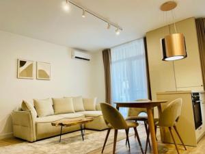 a living room with a couch and a table and chairs at Joy City Stay Vivalia 7B-26 in Timişoara