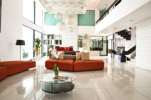 sala de estar con sofá rojo y mesa de cristal en Hotel Expo Plaza Business and Family Guadalajara, en Guadalajara