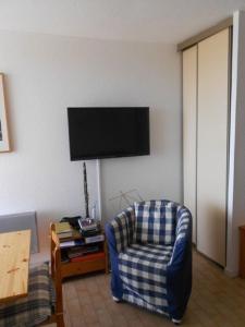 sala de estar con silla y TV de pantalla plana en studio 3 personnes accès direct plage - parking privé - 3TVP30, en Le Barcarès