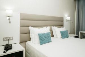 a hotel room with a bed with a phone on it at Carvi Beach Hotel in Lagos