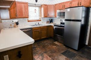 uma cozinha com armários de madeira e um frigorífico de aço inoxidável em Sunnyside Knoll- 17 cabin em Estes Park