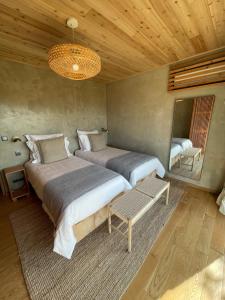 a bedroom with two beds and a chandelier at Casa da Figueira in São Roque do Pico