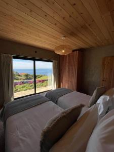 a bedroom with two beds and a large window at Casa da Figueira in São Roque do Pico