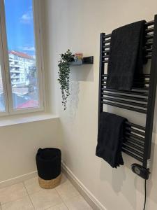 a bathroom with a towel rack and a window at « Le Michelet »un cocon en ville in Saint-Étienne