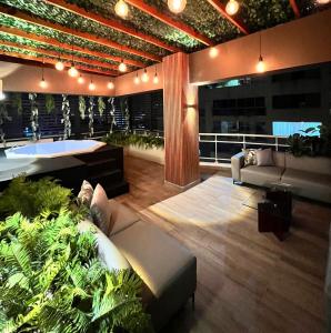 uma sala de estar com um sofá e plantas nele em Central Park Tower em Santo Domingo