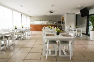 a dining room with white tables and white chairs at Hotel Expo Plaza Business and Family Guadalajara in Guadalajara