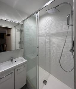 La salle de bains est pourvue d'une douche en verre et d'un lavabo. dans l'établissement Maisonnette, résidence au calme avec terrasse et parking privé 4AM21, au Barcarès