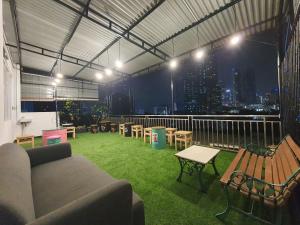 a rooftop patio with a couch and tables and chairs at Multi 88 Syariah in Jakarta
