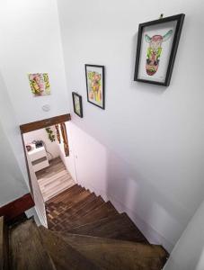 a hallway with stairs with paintings on the wall at Charmant DUPLEX - centre de Fontainebleau in Fontainebleau +5 photos