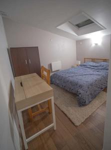 a bedroom with a bed and a wooden table at Charmant DUPLEX - centre de Fontainebleau in Fontainebleau