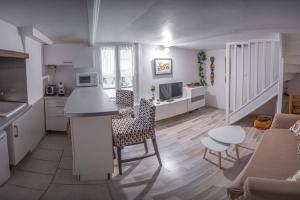a kitchen and living room with a table and chairs at Charmant DUPLEX - centre de Fontainebleau in Fontainebleau