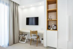 a room with a desk with a tv and a chair at euphoria boutique hotel in Chrysi Ammoudia