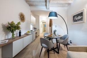 a kitchen and living room with a table and chairs at Fiordaliso Boutique Apartments in Florence