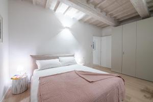 a bedroom with a large bed in a white room at Fiordaliso Boutique Apartments in Florence