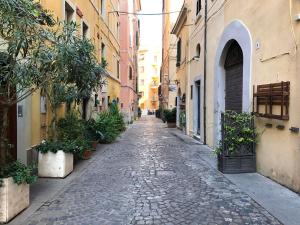an empty street in an alley between buildings at The House of the poet in Civitavecchia
