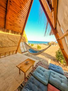 a hammock in a room with a view of the beach at Aladdin Camp in Nuweiba