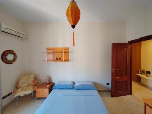 sypialnia z niebieskim łóżkiem i krzesłem w obiekcie Casa Lov (Politeama) w mieście Palermo