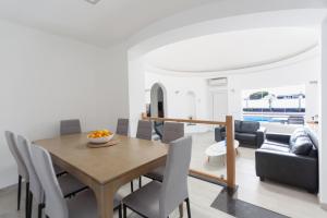 a dining room and living room with a table and chairs at 4 bedroom Villa Mimi with private heated pool in Puerto del Carmen