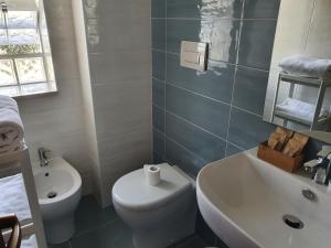 y baño con aseo blanco y lavamanos. en B&B Da Nonna Lucia, en Roccascalegna