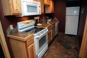 a small kitchen with a stove and a refrigerator at Timber Creek Chalets- 3 chalet in Estes Park