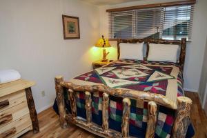a bedroom with a wooden bed with a wooden floor at Timber Creek Chalets- 3 chalet in Estes Park