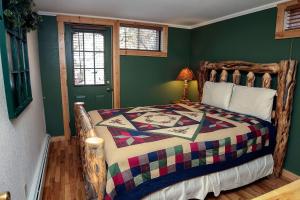 a bedroom with a bed with a colorful quilt at Timber Creek Chalets- 3 chalet in Estes Park