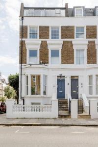 a large white house with blue doors and stairs at Luxury flat on Fulham/Chelsea border in London