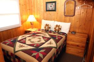 a bedroom with a bed with two teddy bears on it at Lazy R Cottages- 1 apts in Estes Park