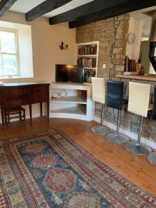 uma sala de estar com uma secretária, cadeiras e um tapete em Gurteen farm house em Clonmel