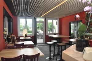 Un restaurante con mesas, sillas y ventanas. en Hôtel des Voyageurs Restaurant Traiteur, en Bagnols
