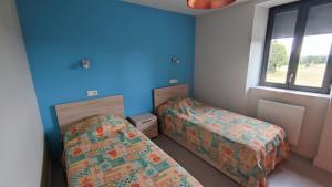 Flayat的住宿－Gite étape la Belle étoile de Flayat，一间卧室设有两张床和窗户。