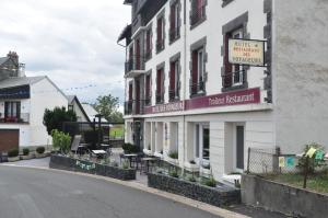 Un edificio con un cartel de hotel al lado de una calle. en Hôtel des Voyageurs Restaurant Traiteur, en Bagnols