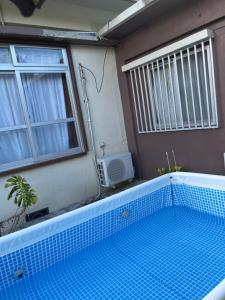 einem Pool vor einem Haus mit Fenster in der Unterkunft カビラハウス Kabira House 窓から見える川平湾まで徒歩1分 in Ishigaki-jima