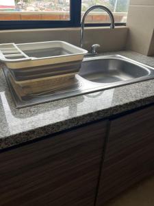 a stainless steel sink in a kitchen with a window at Casa Crema in Cuenca