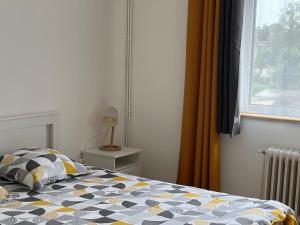 a bedroom with a bed with a pillow and a window at Maison chaleureuse avec jardin - Pause Normande in Sées