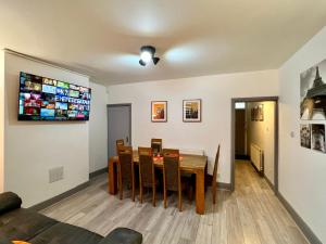 a dining room with a table and a tv on the wall at St Michael's House - Urban Oasis Townhouse in Nottingham