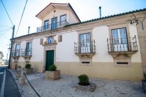 un gran edificio blanco con balcones en una calle en Casa do Compasso, en Farminhão