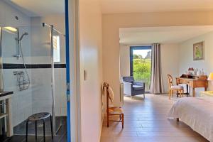 una habitación de hotel con ducha y un dormitorio en GITE ROSCLEDAN contemporain, 3 chambres idéalement situé, en Arradon