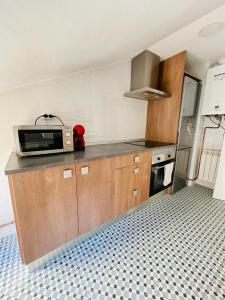 a kitchen with a microwave on a counter and a stove at La Casa del Rock in Aranda de Duero
