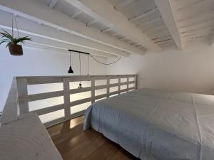 a white bedroom with a bed and a fence at Guest House SanSiro Fiera in Milan