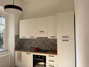 a kitchen with white cabinets and a sink at Guest House SanSiro Fiera in Milan