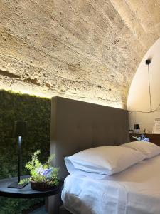 a bedroom with a bed and a stone wall at SottoCasa Casavacanze in Canosa di Puglia