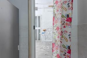a room with a table and a curtain with flowers at Moretti Home in Bari