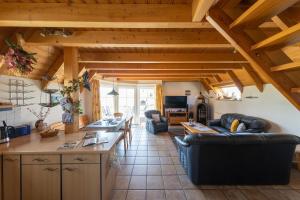 a kitchen and living room with wooden ceilings at HA 17 - Strandvogt 3 Komfort in Schottwarden